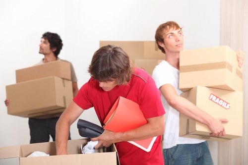 Trained moving staff preparing furniture with protective equipment