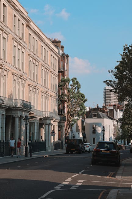 A street scene in Parsons Green showing a row of elegant, cream-colored Victorian-style terraced houses with decorative window frames, balconies, and iron railings along the facades. The pavement adja
